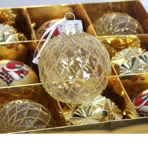 Nahaufnahme einer klaren strukturierten Weihnachtskugel mit Goldglitter-Gittermuster in Geschenkbox.