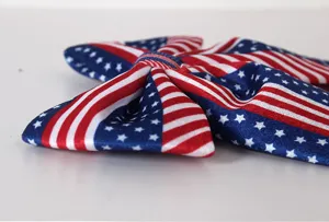 Detailed close-up of American flag velvet bow ornament showing fabric texture and stars pattern.