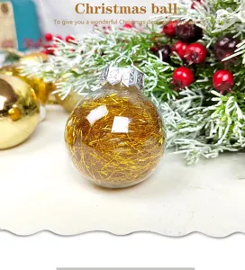 Clear plastic Christmas ball filled with gold tinsel for holiday tree decoration detail.