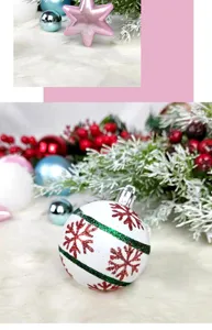 Detailed view of white Christmas ball ornament with red snowflakes and green glitter stripes.