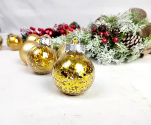 Close-up of clear plastic Christmas bauble filled with sparkling gold glitter and festive decor.