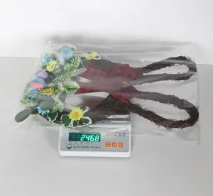 Easter bunny wreath detail view featuring woven twig, colorful eggs, flowers, and plaid bow.