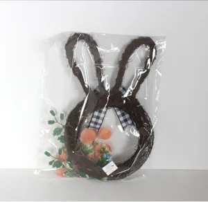 Close-up detail of Easter rabbit twig wreath with black and white plaid bow and leaves.