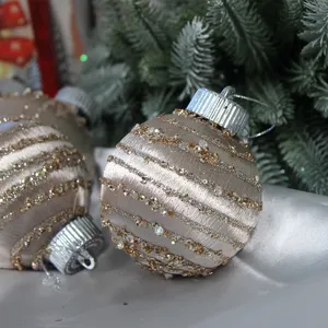 Bolas de navidad color champán con rayas brillantes y tapas plateadas para decoración.