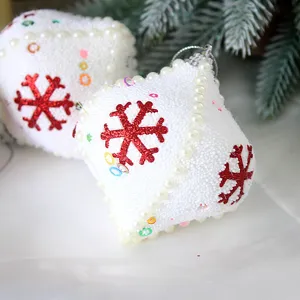 White foam Christmas onion ornaments with red glitter snowflakes and pearl chains for tree.