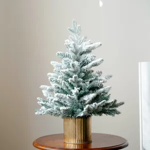 Primo piano dettagliato dei rami dell'albero di Natale in miniatura floccato con effetto neve e vaso.
