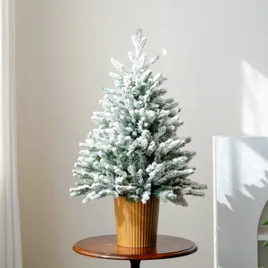 Vista dettagliata di un piccolo albero di Natale innevato, decorazione da tavola.