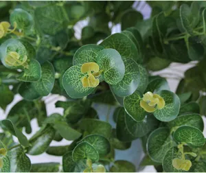 Close-up detail of artificial eucalyptus leaves with clear veins, vibrant green plant decor.