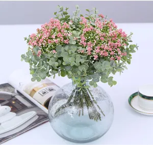 Artificial baby's breath eucalyptus bouquet in glass vase, close-up interior home decor detail view