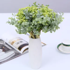 Artificial eucalyptus and baby's breath flower bouquet in white ceramic vase for home decor