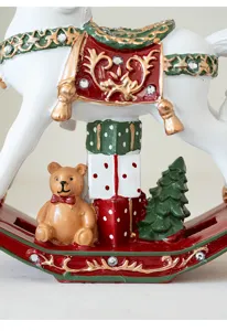 Close-up detail of Christmas resin rocking horse ornament with teddy bear and gift box decor.