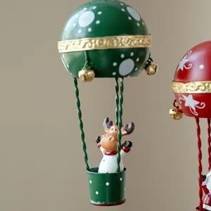 Christmas metal hot air balloon hanging ornament with cute reindeer figurine inside basket.
