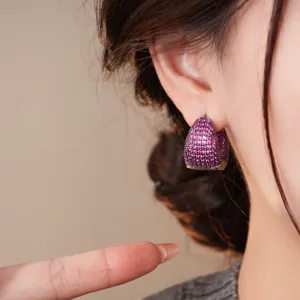 Primo piano dettaglio di orecchini a cerchio goccia zircone rosa, moda elegante.