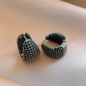 Primo piano dettagliato di orecchini a cerchio in zircone nero, design pavé scintillante.