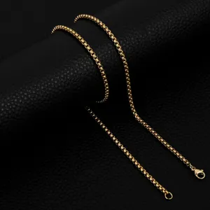 Gold stainless steel box chain detail closeup, elegant shiny jewelry necklace link display.