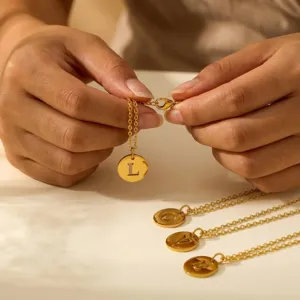 Close-up detail of gold stainless steel initial letter pendant necklace with delicate chain.