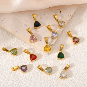 Gros plan détaillé de pendentifs breloques en zircon triangulaire géométrique coloré.