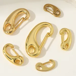 Close-up shot of polished gold stainless steel lobster clasps and jewelry connectors in multi sizes.