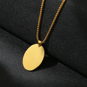 Close-up view of a gold-colored blank oval pendant necklace with chain, ideal for custom DIY engraving.