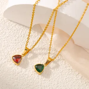 Vue de détail en gros plan de colliers pendentifs en zircon rouge et vert triangulaires.
