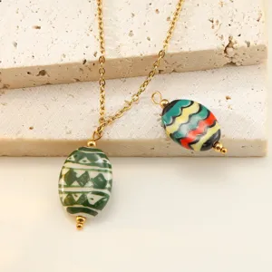Closeup detail of handmade ceramic oval pendant necklace with stainless steel chain.