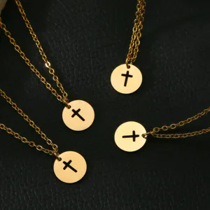 Detail view of gold stainless steel cutout cross round disc pendant necklaces on texture.