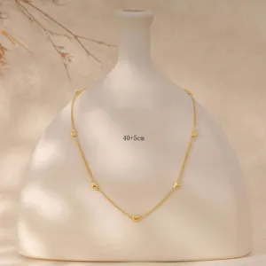 Detail view of a delicate gold-tone necklace featuring lovely heart charms on a sleek chain.