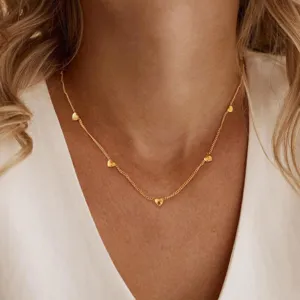 Elegant gold station necklace with multiple small heart charms for women and daily wear fashion.
