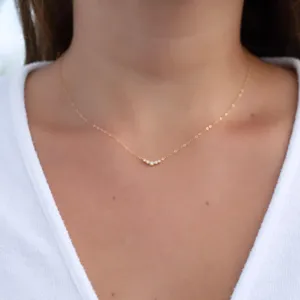 Delicate gold-toned clavicle chain featuring a curved row of sparkling cubic zirconia stones.