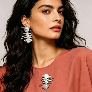 Set di orecchini e spilla geometrici argentati, primo piano dettagliato per la moda.