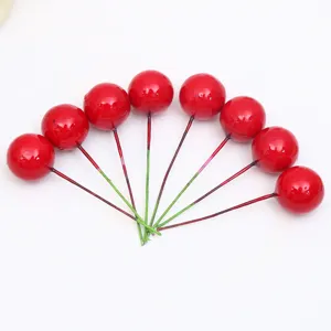 Primer plano de tallos de bayas rojas artificiales, fruta de espuma para decoración DIY.