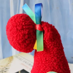 Red plush faceless doll hat with colorful ribbons, festive cute plush toy decoration.