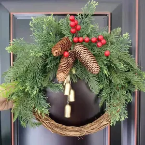 Christmas wreath with pinecones red berries and bells for holiday door hanging decor.