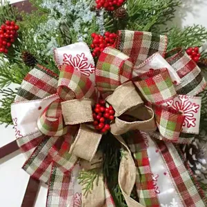 Weihnachtskranz Schleife Dekoration mit rot grün karierten Jute Bändern und Zapfen für Feiertag.