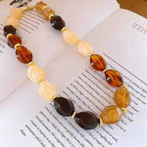 Chic geometric acrylic beaded statement necklace with stylish brown and gold tone elements.