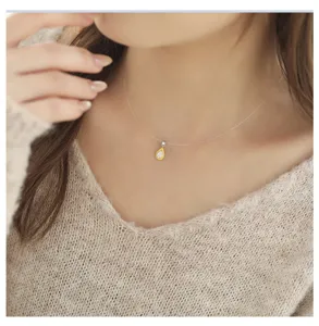 Detailed view of dainty sterling silver teardrop pendant necklace on transparent chain.
