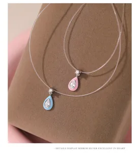 Pendant necklace detail shot, teardrop zirconia design with clear fishing line choker.