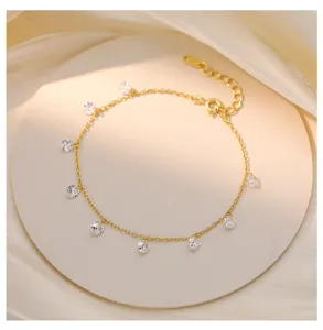 Gros plan détaillé d'un bracelet de chaîne plaqué or délicat orné de pendentifs en zircone.