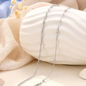 Detailed close-up shot of the delicate silver-toned double layer chain anklet with beads.