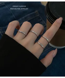 Close-up van minimalistische S925 sterling zilveren alfabet letterringen gedragen.