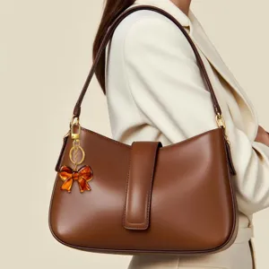 Bolso de hombro marrón retro chic con elegante accesorio colgante de lazo de resina.