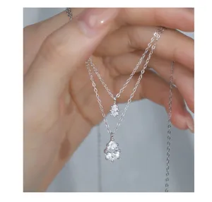 Close-up detail of double layered silver pear cut necklace, sparkling pendant shine.
