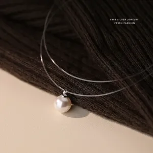 Prachtig detailzicht van de zwevende parelketting met onzichtbare vislijn hanger.