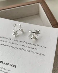 Silver pearl star earrings detail shot showcasing intricate design and fine texture.