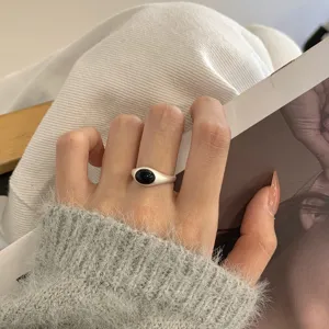 Gedetailleerd opname van een minimalisten s925 zilveren ring met zwarte steen.