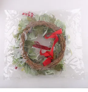 Christmas artificial wreath with red velvet bow and berries for holiday home decor.