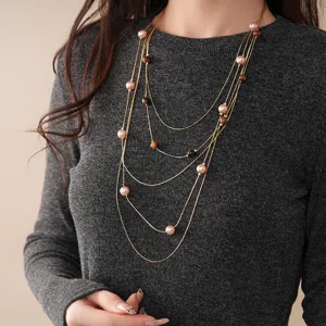 Detail view of multi-layered pearl and tiger's eye beaded necklace, elegant sweater chain.
