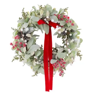 Christmas artificial wreath with red velvet bow, frosted leaves, berries and pine cones