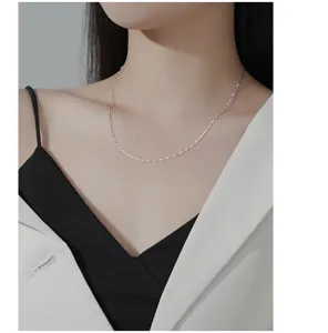 Gros-plan d'un collier de chaîne de clavicule en argent sterling fin avec un bel éclat.