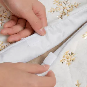 Gonna per albero di Natale in peluche bianco con fiocchi di neve dorati e velcro.